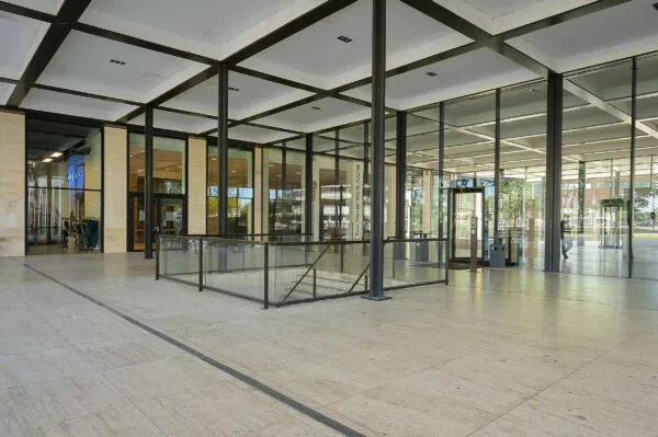 Entree van een modern kantoorgebouw aan de Galvanistraat met glazen gevel en betonnen pilaren.