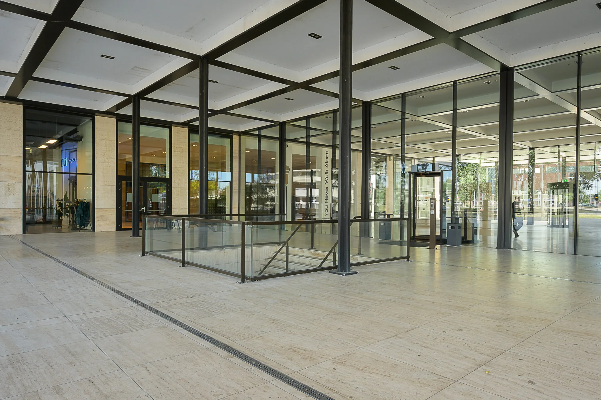 Entree van een modern kantoorgebouw aan de Galvanistraat met glazen gevel en betonnen pilaren.