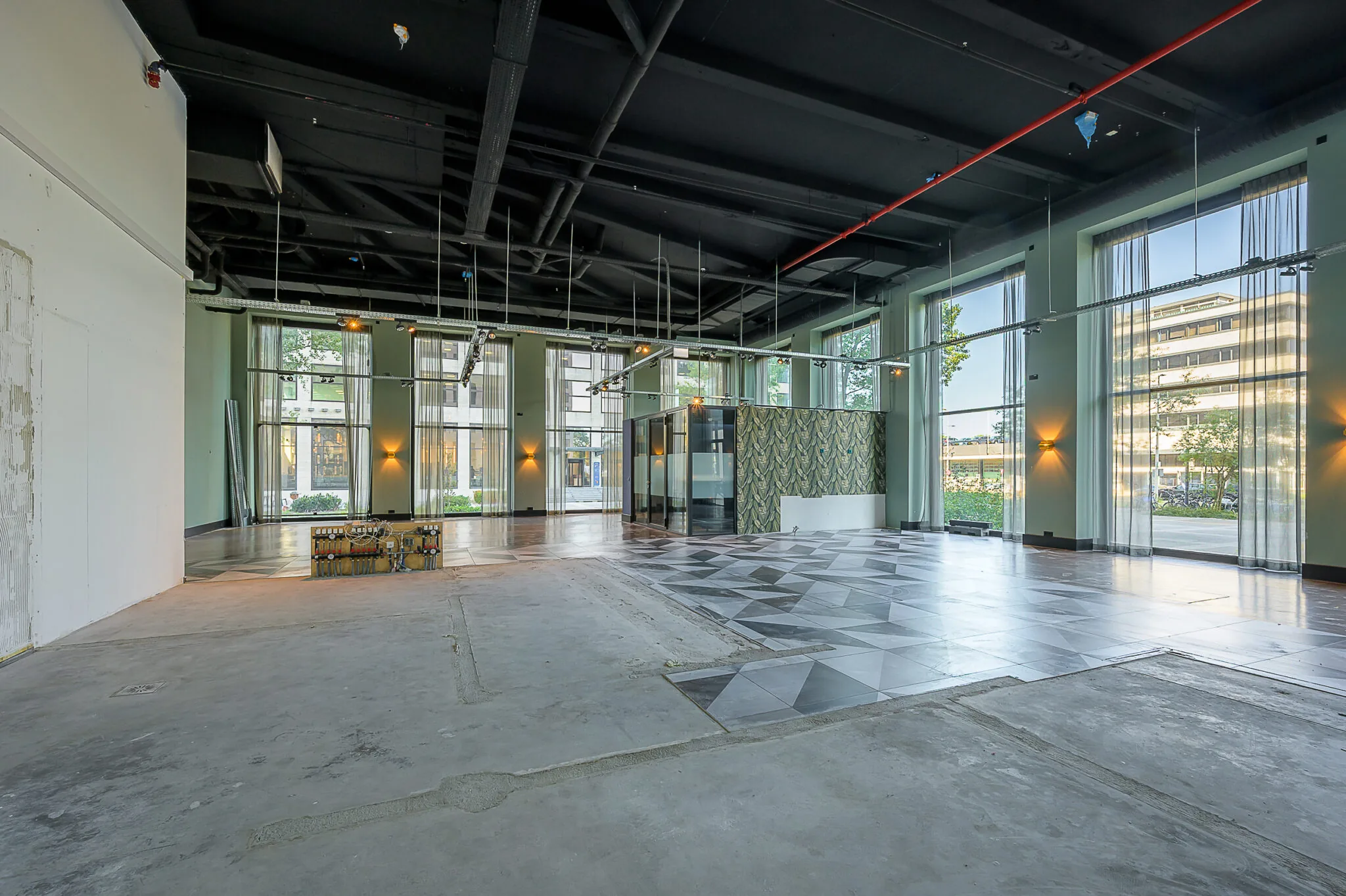 Binnenruimte aan de Galvanistraat met hoge plafonds, grote ramen en deels betegelde vloer.