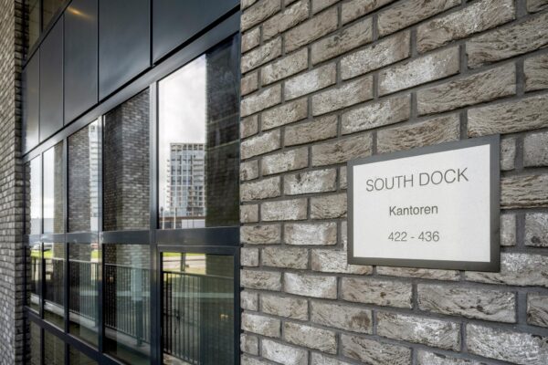 Gevel van het kantoorgebouw South Dock met een bord waarop de adressen 422–436 staan.