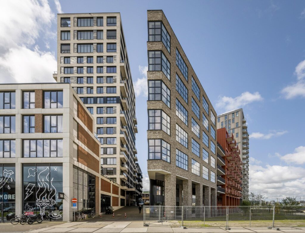 Moderne appartementengebouwen langs de Hellingbaan met industriële architectuur en grote ramen.