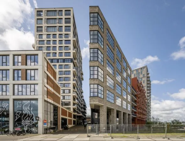 Moderne appartementengebouwen langs de Hellingbaan met industriële architectuur en grote ramen.
