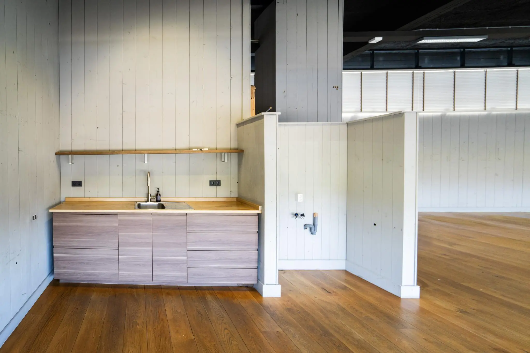 Moderne kitchenette met houten afwerking in een leegstaand interieur aan de Schiedamsedijk.