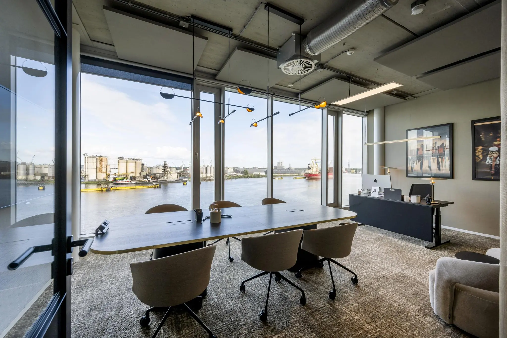 Modern kantoor aan de Moermanskade met vergadertafel en uitzicht op het havengebied.