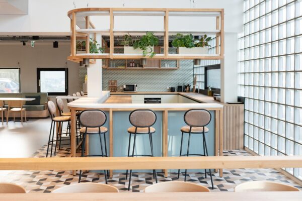 Moderne open keuken met bar, hoge krukken en hangende planten aan de Overschiestraat.