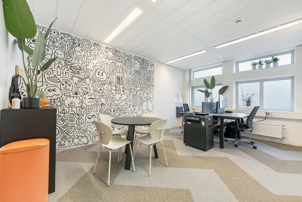 Modern kantoor aan de Daltonlaan met creatieve muurtekening en zitgedeelte.