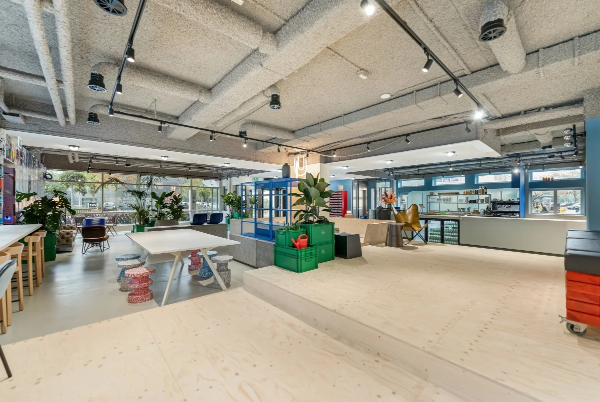 Modern ingerichte kantoorruimte aan de Daltonlaan met open indeling, flexwerkplekken, planten en een koffiebar.