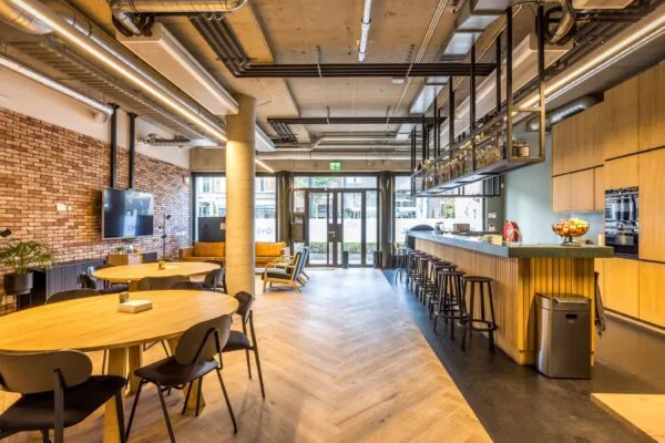 Moderne en sfeervolle kantoorruimte aan de Overtoom met open keuken, zithoeken en houten afwerking.