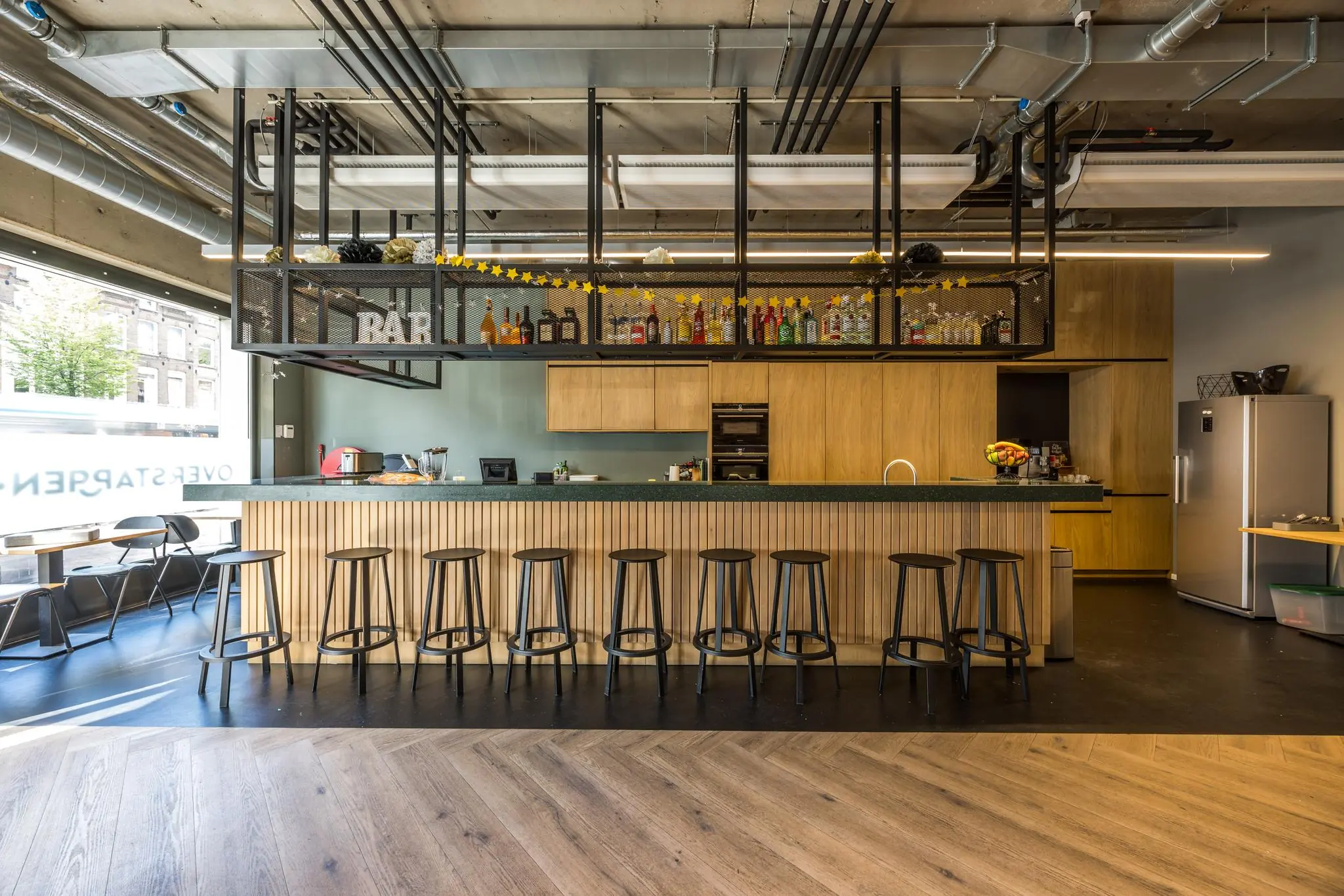 Moderne keuken met bar en barkrukken in een industrieel ingericht interieur aan de Overtoom.
