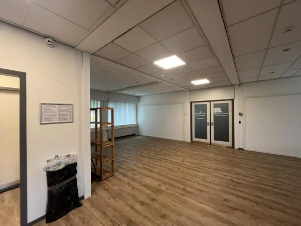 Lege binnenruimte met houten vloer en glazen deuren van Business Center Het Coachhuis aan de 2e Daalsedijk.