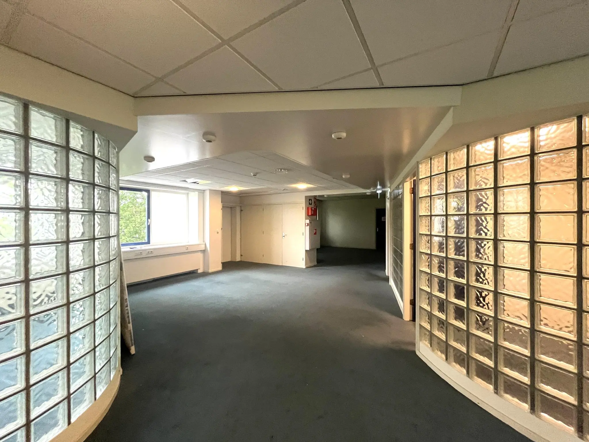 Hal met glazen bouwstenen, witte plafonds en een raam aan de 2e Daalsedijk.