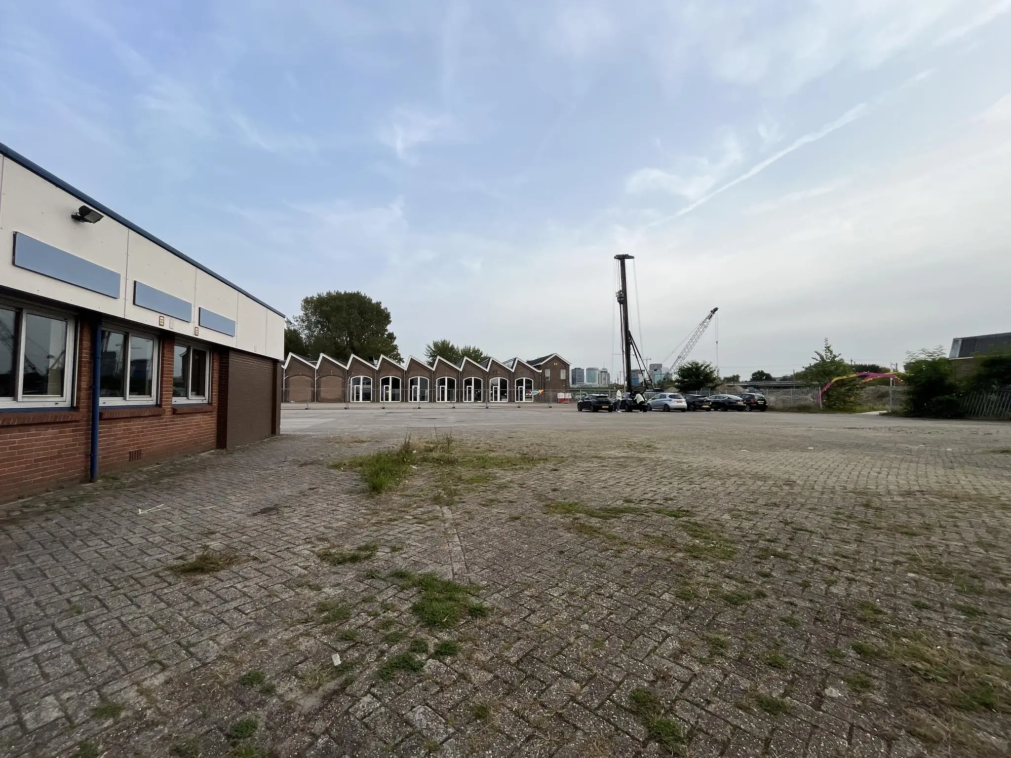 Plein met verouderde bebouwing aan de 2e Daalsedijk in Utrecht, met geparkeerde auto's en een heistelling op de achtergrond.