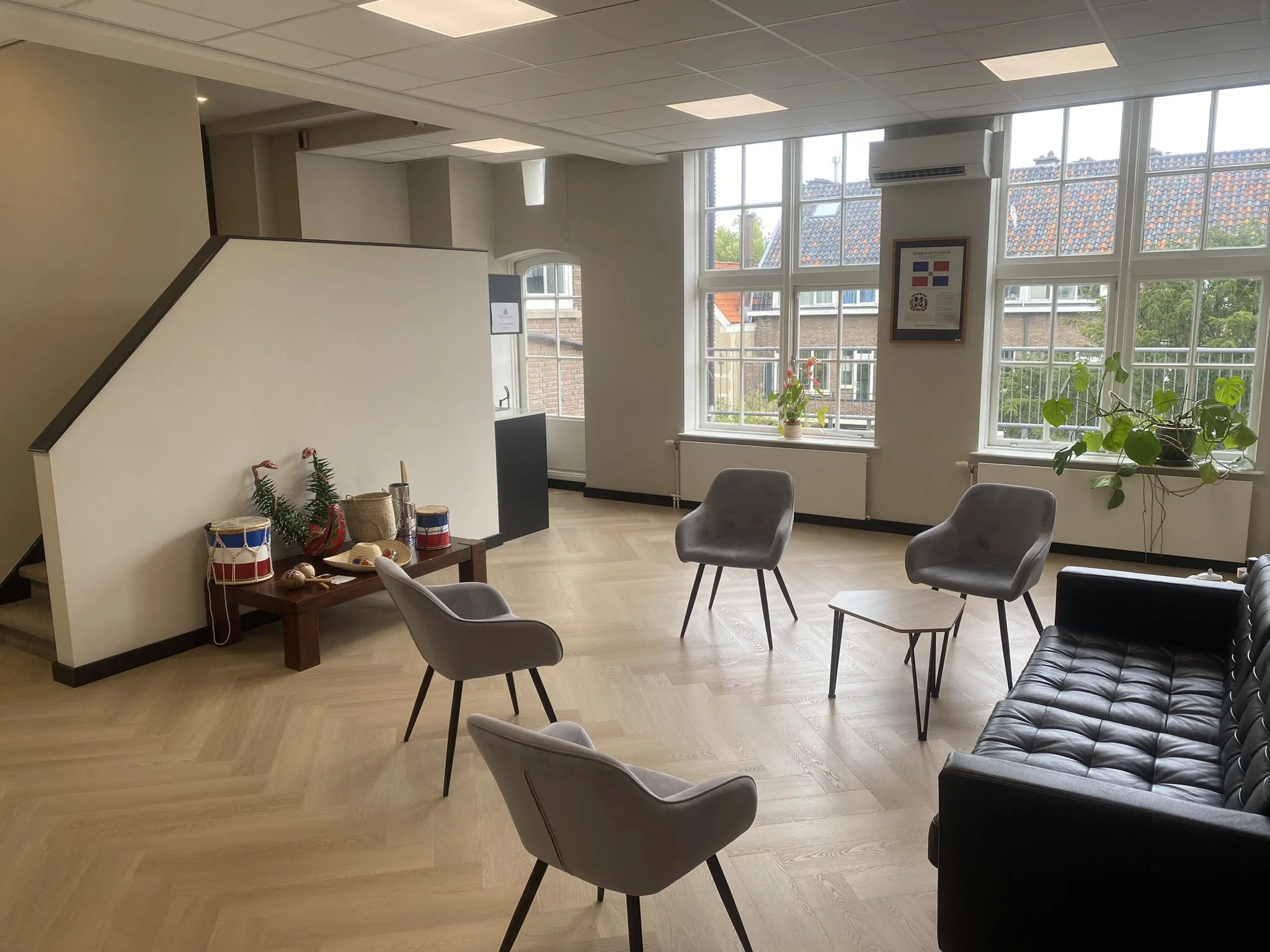 Moderne wachtruimte aan het Lange Voorhout met zitmeubilair, grote ramen en decoratieve elementen.