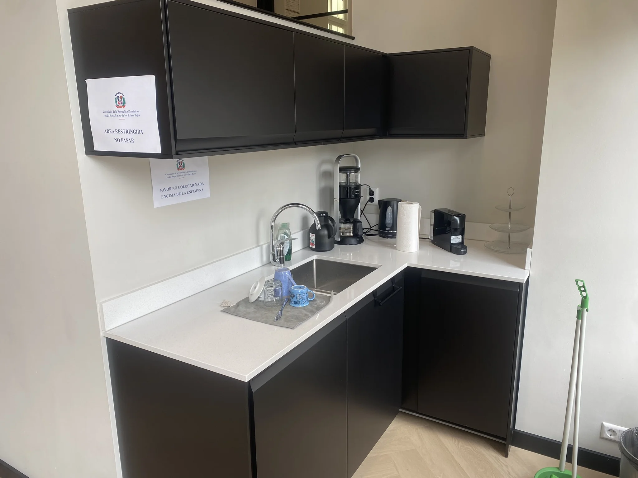 Keukenhoek met zwarte kasten, koffiemachines en een gootsteen in het consulaat aan het Lange Voorhout.