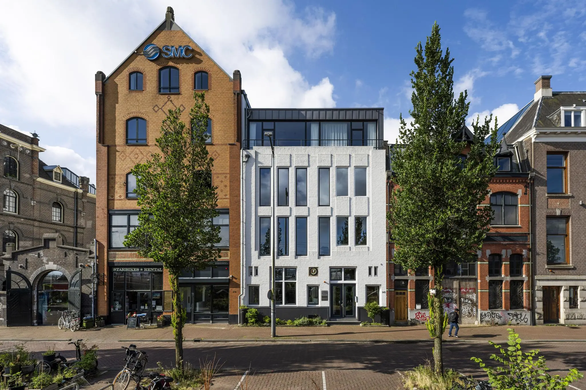 Gevelaanzicht van diverse panden aan de De Ruijterkade in Amsterdam, met een mix van moderne en historische architectuur.