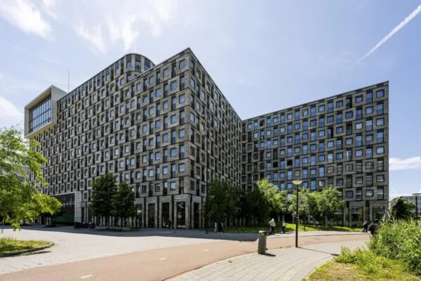 Groot modern appartementengebouw aan het Elizabeth Cady Stantonplein met een gevel vol vierkante ramen.