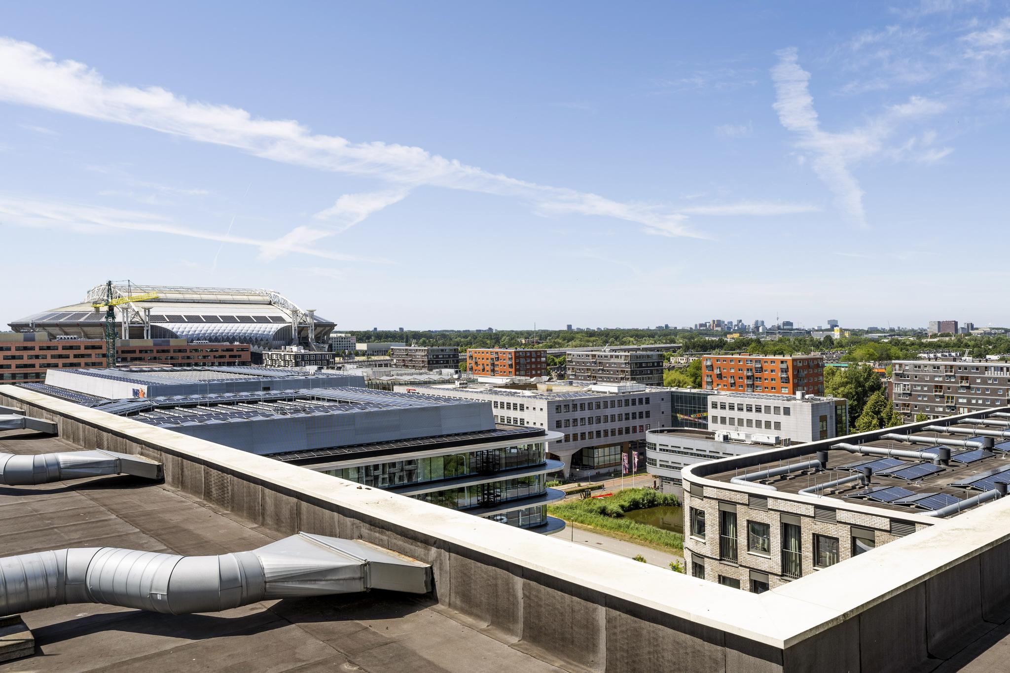 Uitzicht vanaf een dak op het Elizabeth Cady Stantonplein met het Johan Cruijff ArenA-stadion op de achtergrond.