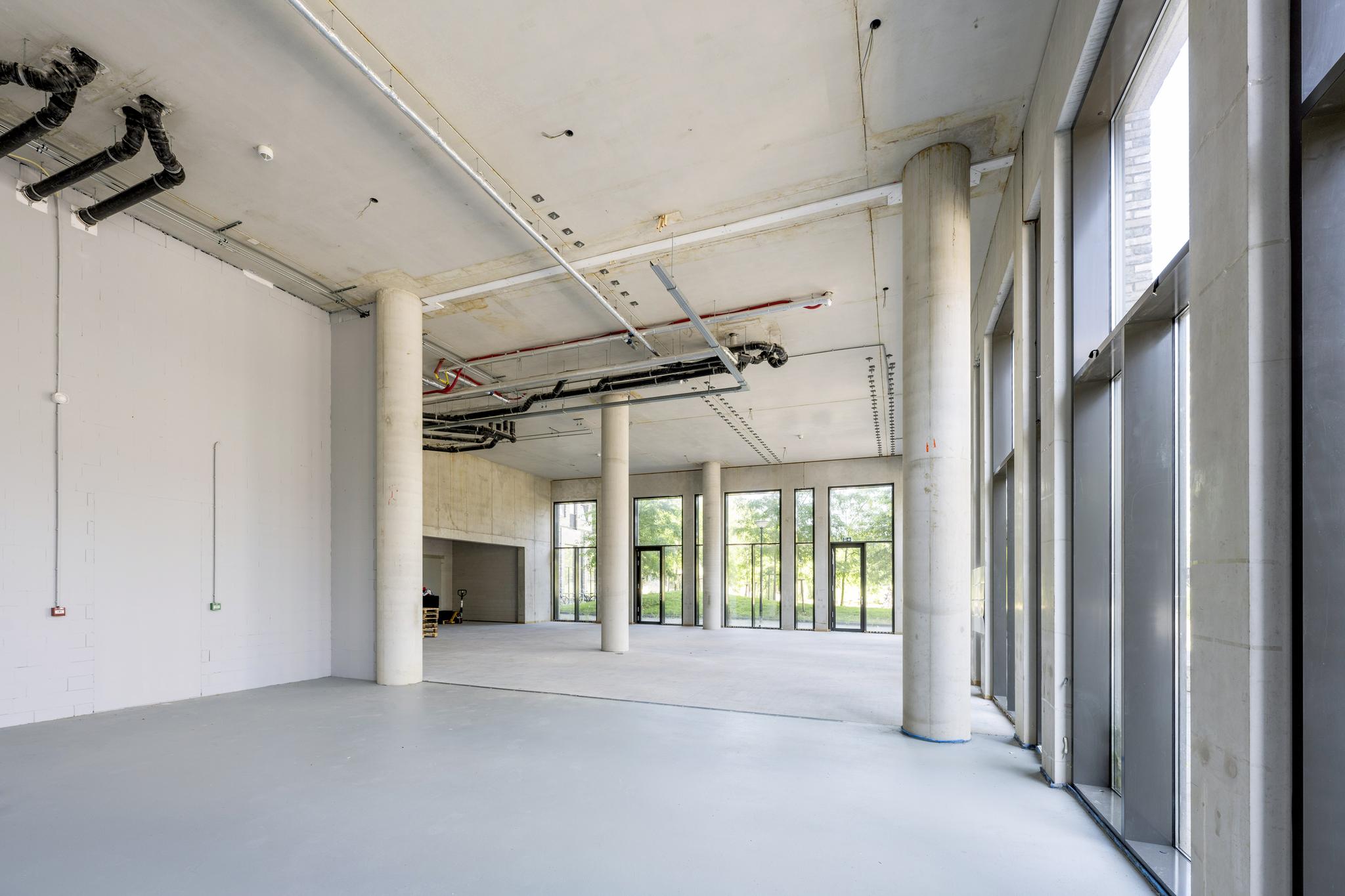 Leeg commercieel casco winkelpand met hoge plafonds en grote raampartijen aan het Elizabeth Cady Stantonplein.