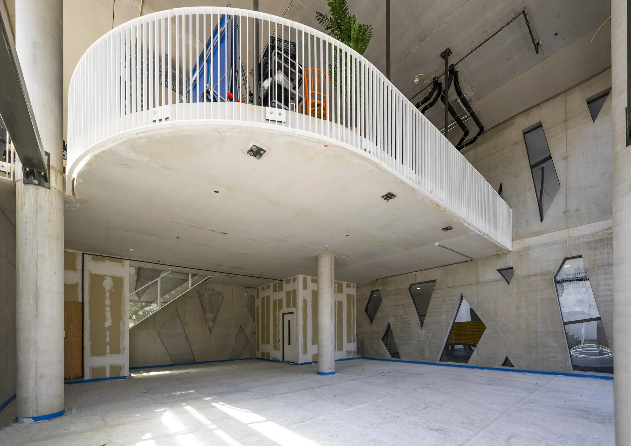 Moderne, betonnen binnenruimte aan het Elizabeth Cady Stantonplein met een ronde vide, witte balustrade en geometrische ramen.