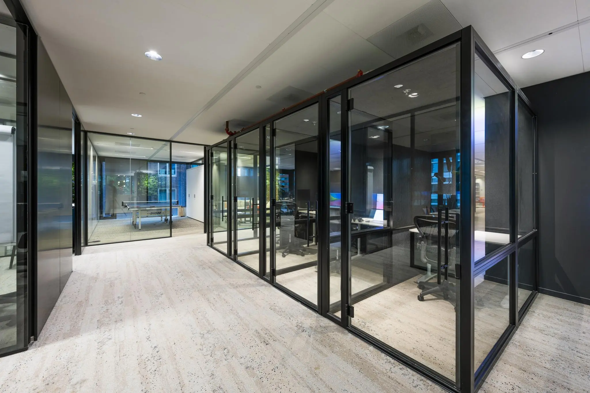 Moderne kantoorruimte aan de Gustav Mahlerlaan met glazen vergaderruimtes en een tafeltennistafel op de achtergrond.