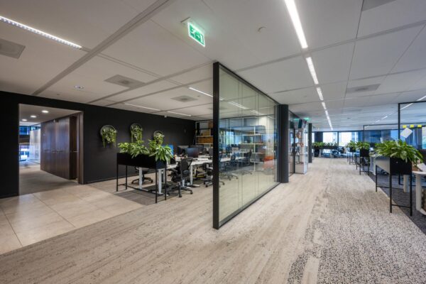 Moderne kantoorruimte aan de Gustav Mahlerlaan met glazen wanden, werkplekken en veel groenvoorziening.