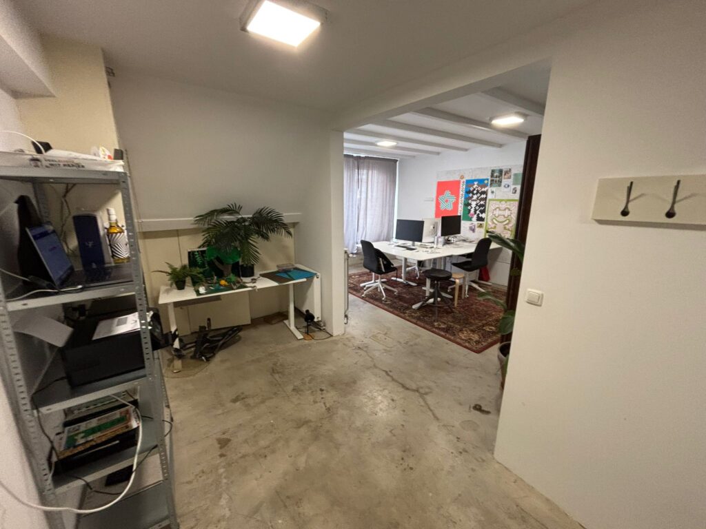 Kantoorruimte aan de Van Ostadestraat met werkplekken, planten en kleurrijke posters aan de muur.