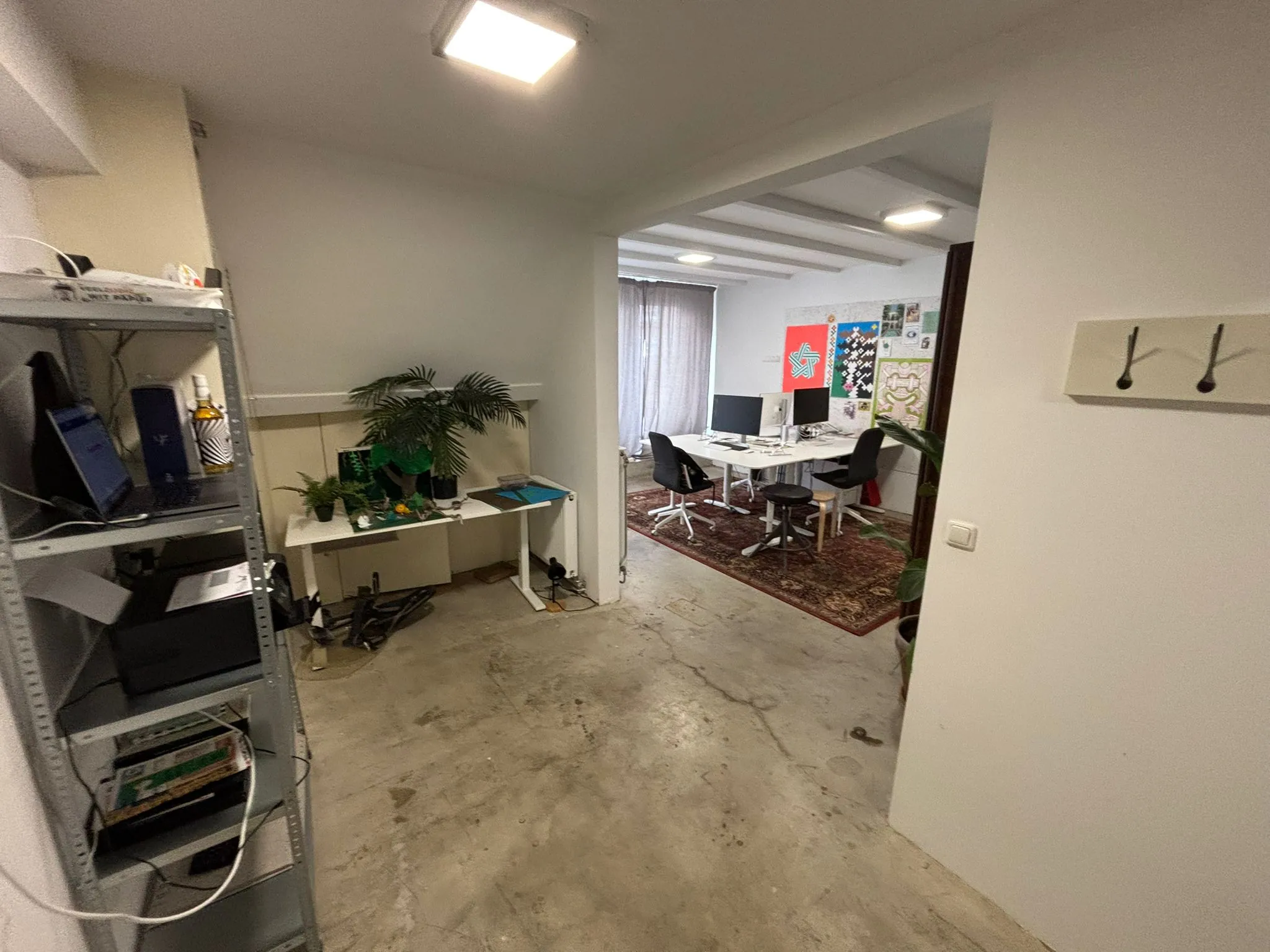 Kantoorruimte aan de Van Ostadestraat met werkplekken, planten en kleurrijke posters aan de muur.