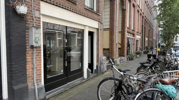 Straatbeeld van de Van Ostadestraat met fietsen, bakstenen gevels en een zwarte voordeur links.