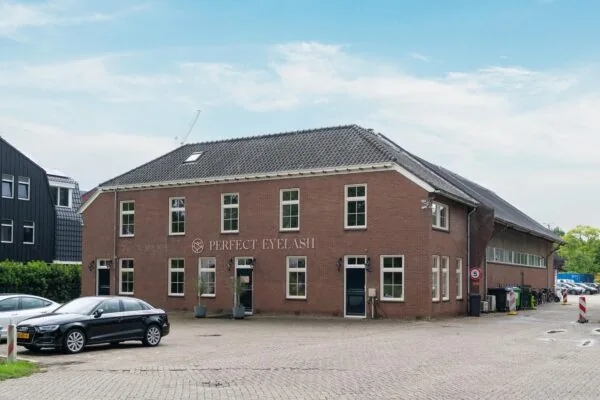 Vooraanzicht van het bakstenen bedrijfspand van Perfect Eyelash aan de Sloterweg, met geparkeerde auto's op de oprit.