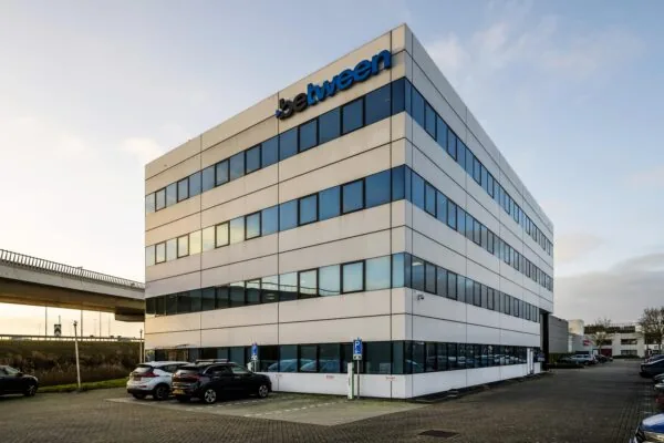 Kantoorgebouw van Between aan de Kuiperbergweg met parkeergelegenheid op de voorgrond.