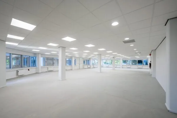 Lichte, lege kantoorruimte aan de Kuiperbergweg met grote ramen en systeemplafond.