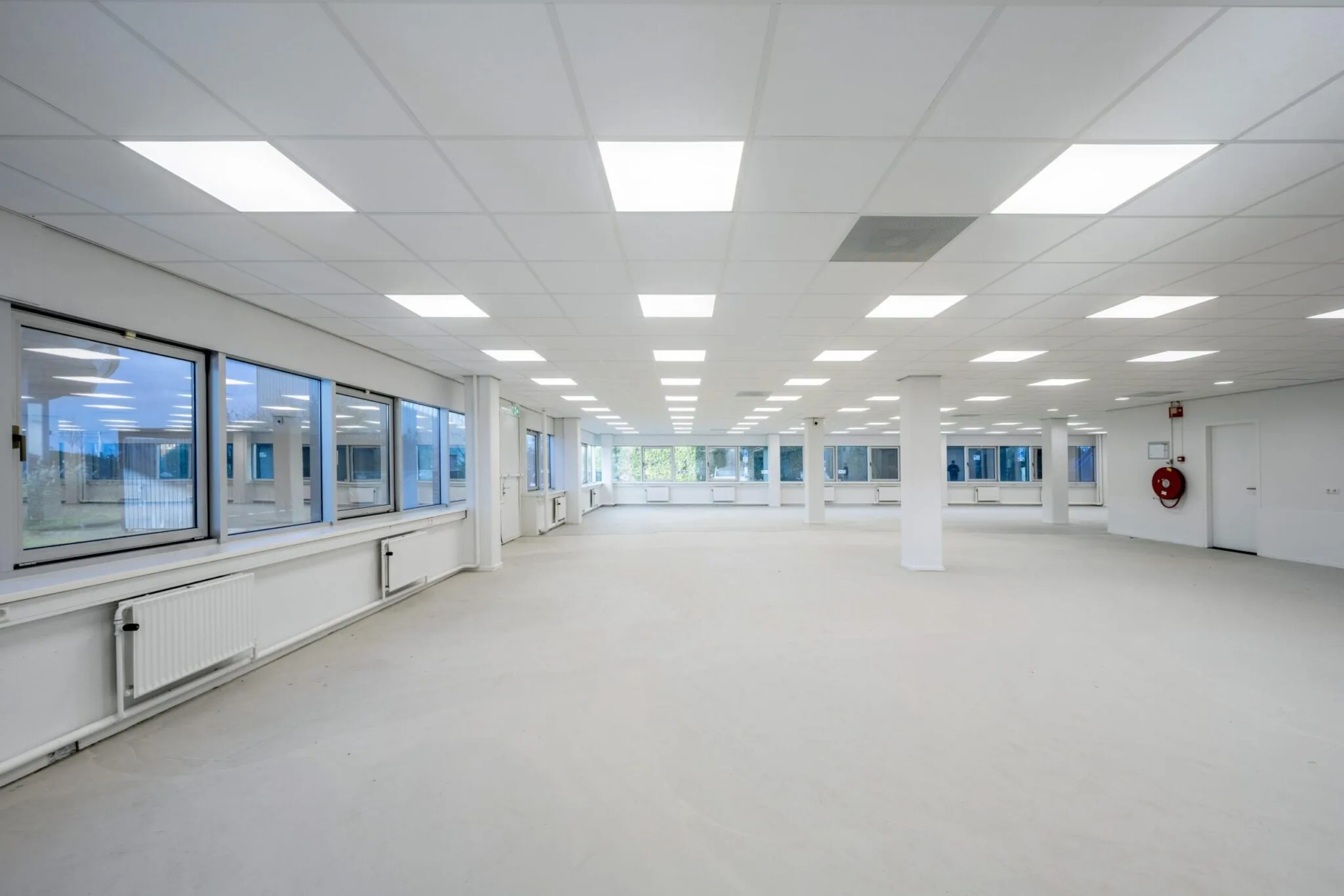 Ruime, lege kantoorruimte aan de Kuiperbergweg met grote ramen en systeemplafondverlichting.