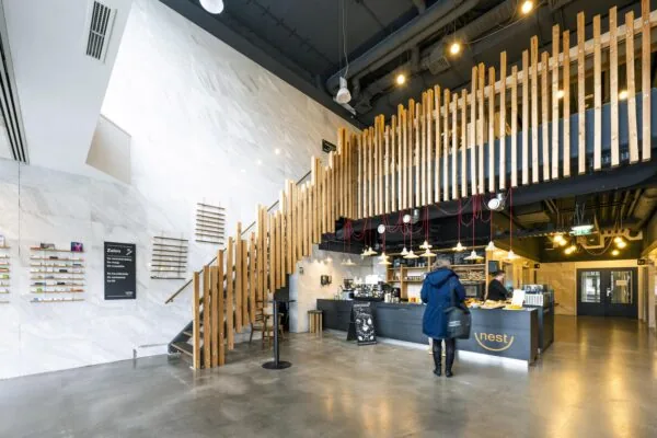 Moderne entreehal met koffiebar Nest, houten trap en inrichting in Laan van Kronenburg.