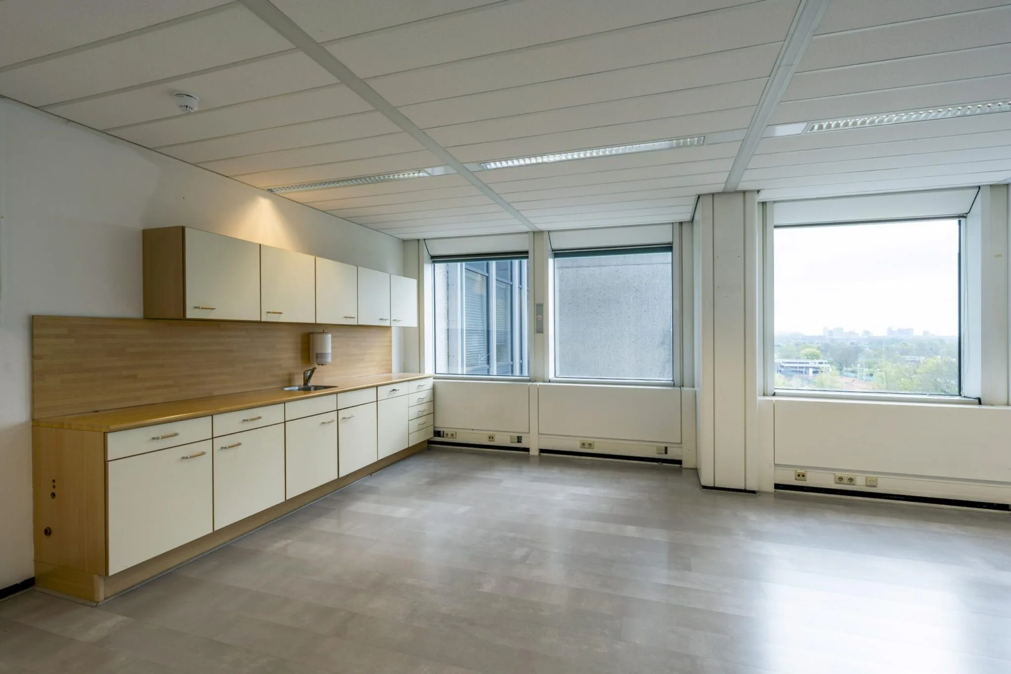 Kantoorpantry met lange keukenopstelling en uitzicht op de Laan van Kronenburg.
