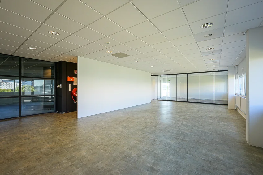 Licht en ruim leeg kantoorpand aan de K.P. van der Mandelelaan met glazen wanden en systeemplafond.