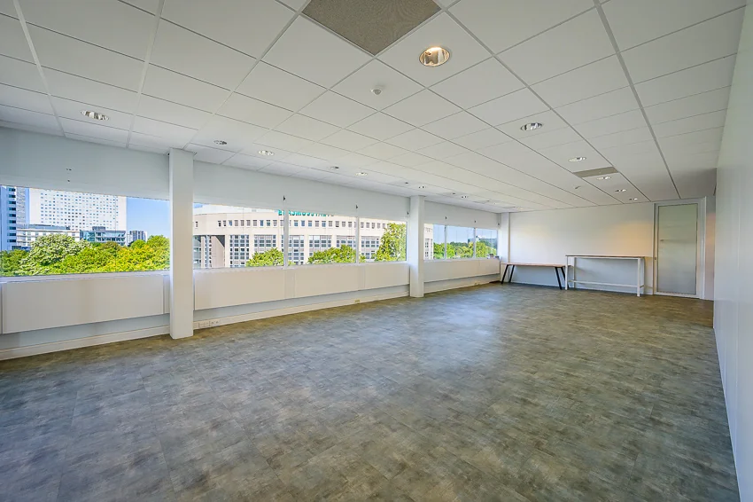Licht en ruim leeg kantoor met grote ramen aan de K.P. van der Mandelelaan.