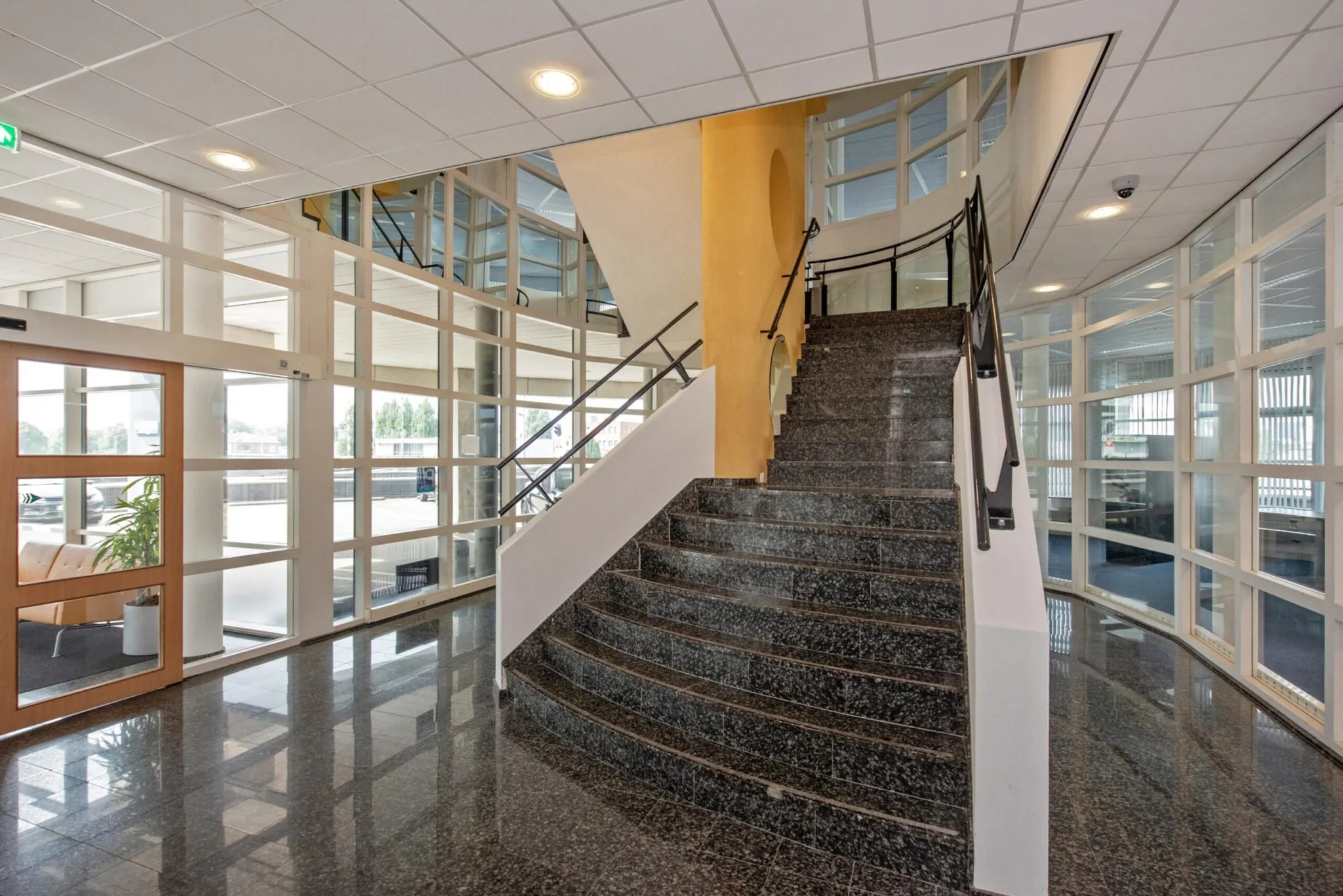 Halfronde marmeren trap in de entreehal van een modern kantoorgebouw aan de Binckhorstlaan.