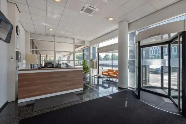 Ingang met receptiebalie en wachtruimte in een modern kantoorpand aan de Binckhorstlaan.