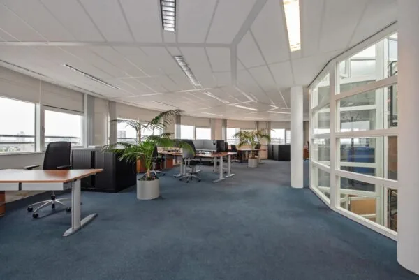Modern, licht kantoorinterieur aan de Binckhorstlaan met werkplekken, bureaustoelen en grote ramen.