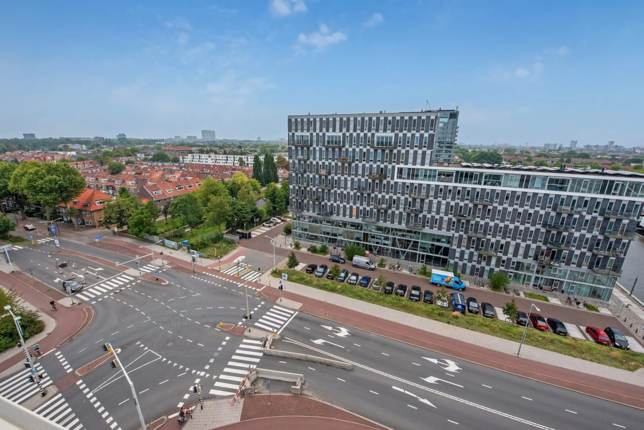Luchtfoto van de Binckhorstlaan in Den Haag met modern kantoorgebouw, woonwijken en kruispunt.