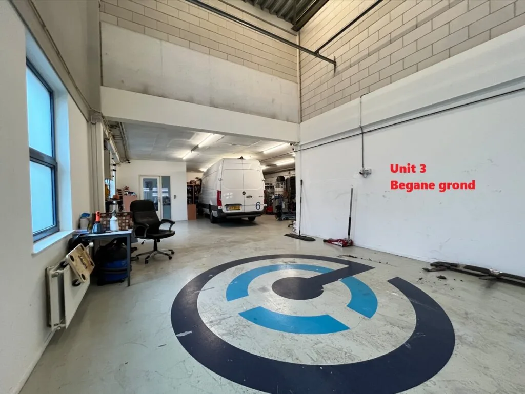 Bedrijfsruimte met een witte bestelbus binnen, werkbanken en stoelen, gemarkeerd als Unit 3 op de begane grond.