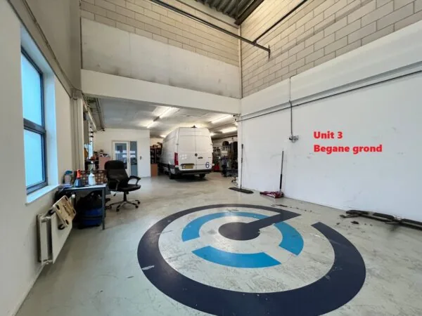 Bedrijfsruimte met een witte bestelbus binnen, werkbanken en stoelen, gemarkeerd als Unit 3 op de begane grond.