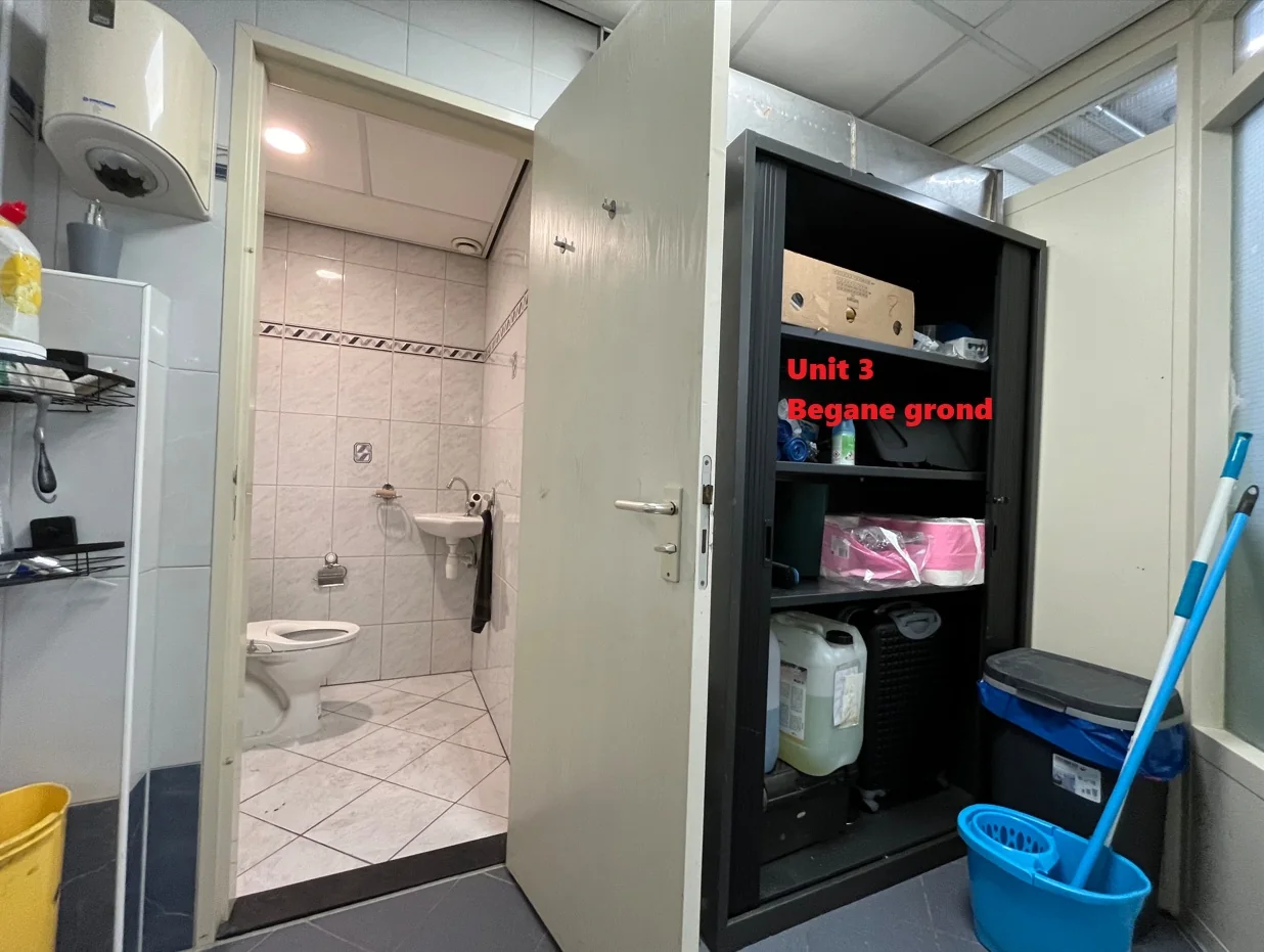Opbergkast en schoonmaakspullen naast een open deur naar een betegeld toilet in Unit 3 op de begane grond.