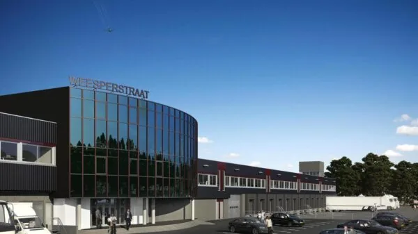 Modern bedrijfspand aan de Weesperstraat met glazen gevel en parkeerterrein op de voorgrond.