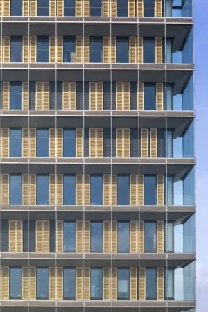 Gevel van het kantoorgebouw aan de Paasheuvelweg met glazen wanden en verticale houten lamellen.