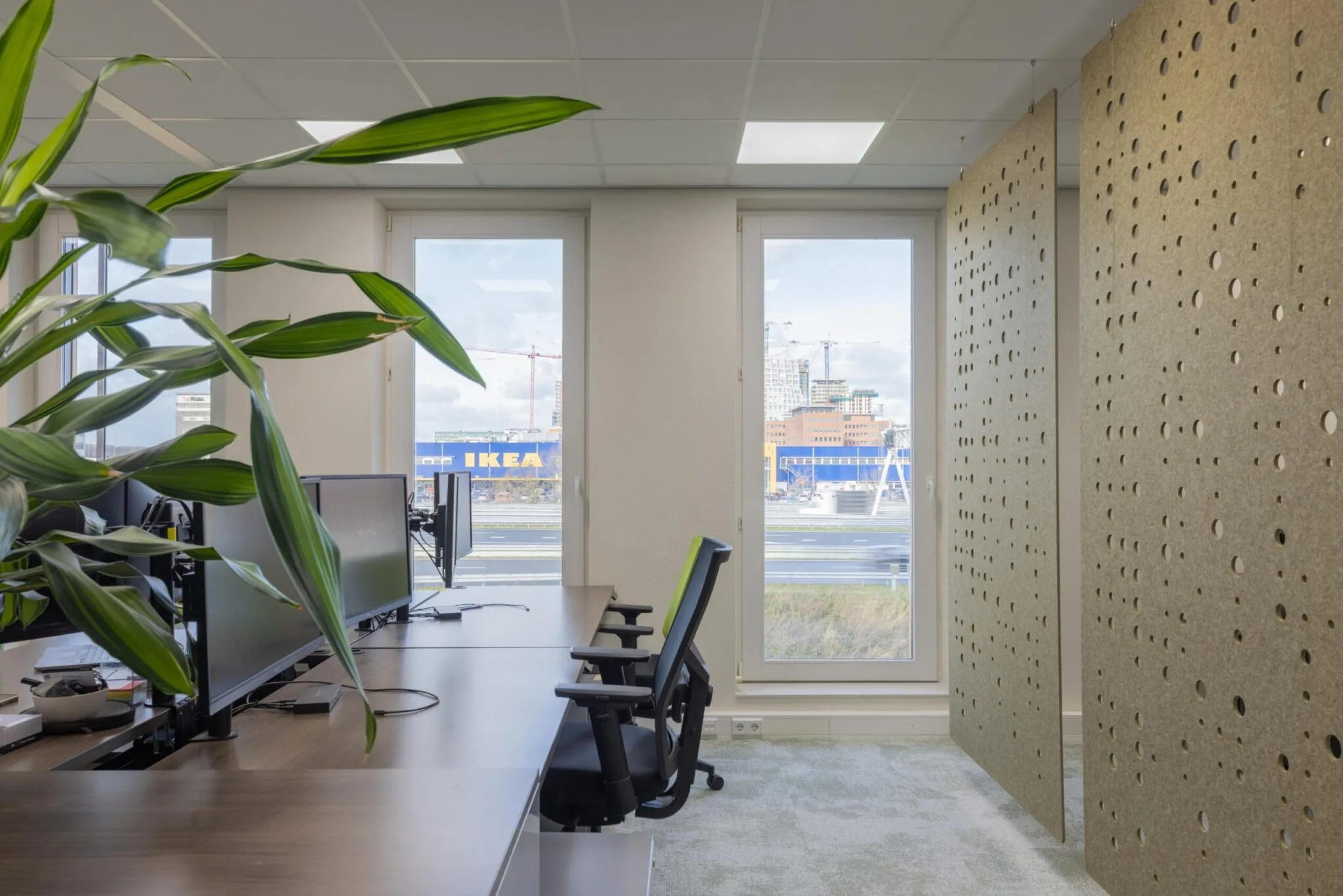 Modern kantoorinterieur aan de Paasheuvelweg met zicht op een IKEA-gebouw en de stad op de achtergrond.