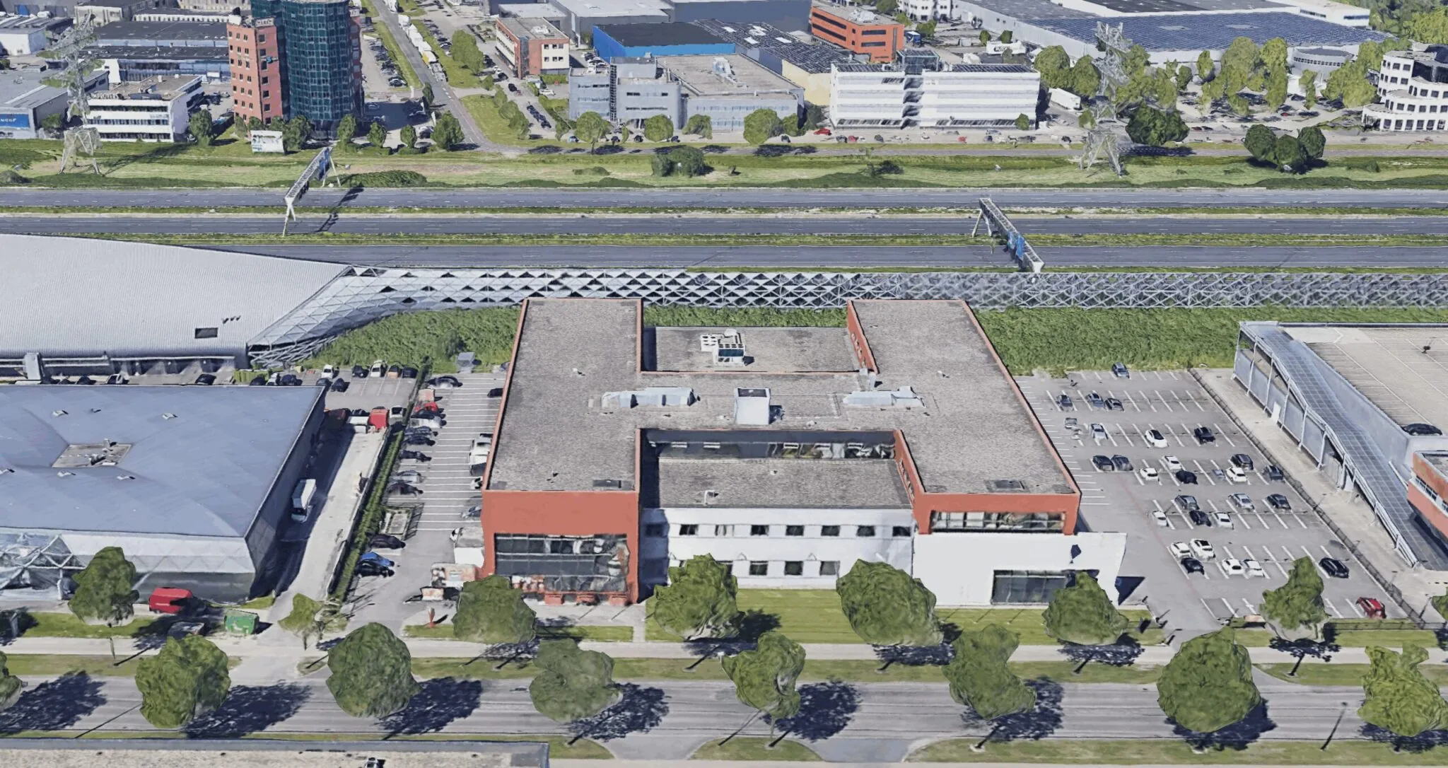 Luchtfoto van een kantoorgebouw aan de Proostwetering in Utrecht met omliggende parkeerplaatsen en snelweg.