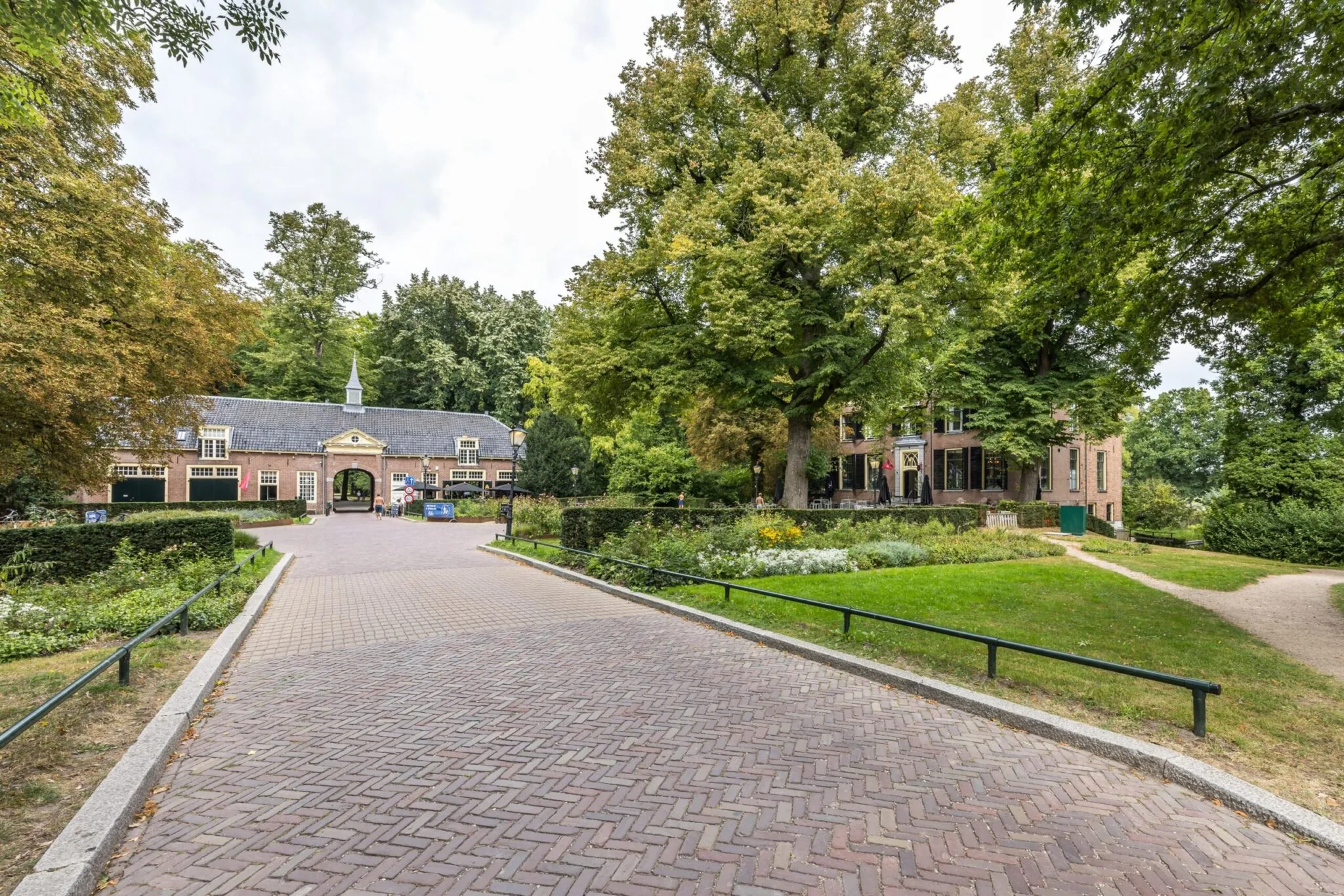 Toegangsweg naar landgoed Vossegatsedijk met monumentaal poortgebouw en omringende tuin.