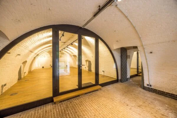 Gerestaureerde ruimte met glazen wand in een gewelfde kelder aan de Vossegatsedijk.