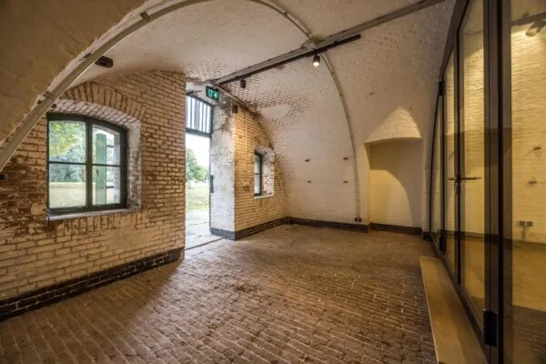 Gerestaureerde bakstenen ruimte met gewelfd plafond aan de Vossegatsedijk, met zicht op buiten door open deur en ramen.